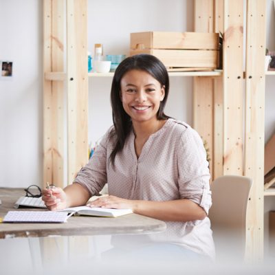 smiling-mixed-race-woman-at-desk-PY2ZLH6.jpg